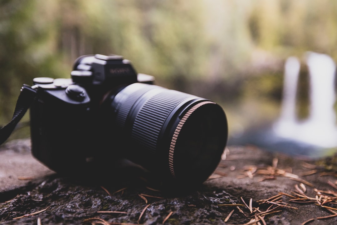 a camera sitting on top of a rock near a waterfall